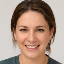 Joyful white young-adult female with medium  brown hair and grey eyes