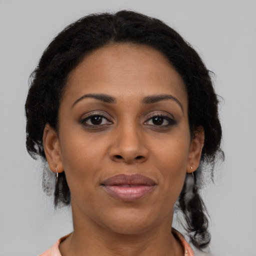 Joyful black adult female with medium  brown hair and brown eyes