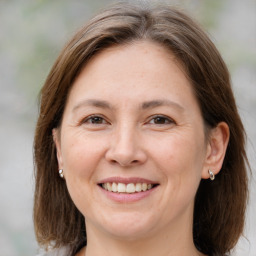 Joyful white adult female with medium  brown hair and grey eyes