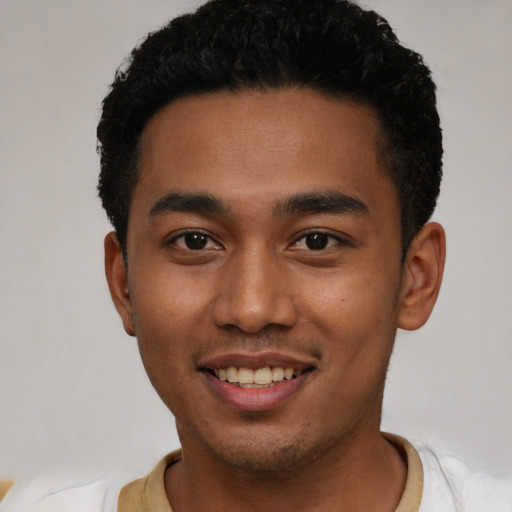 Joyful latino young-adult male with short  black hair and brown eyes