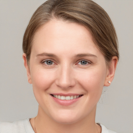 Joyful white young-adult female with short  brown hair and grey eyes