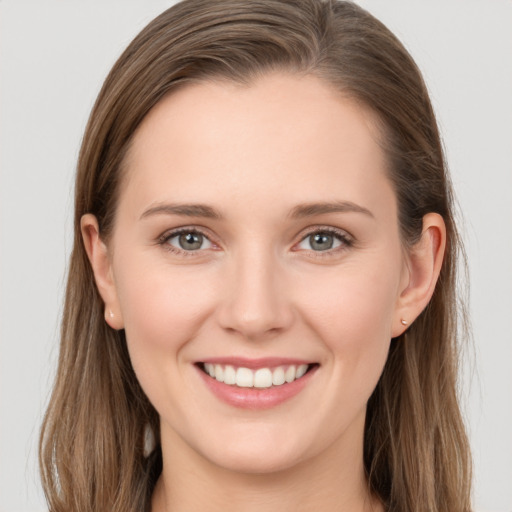 Joyful white young-adult female with long  brown hair and grey eyes