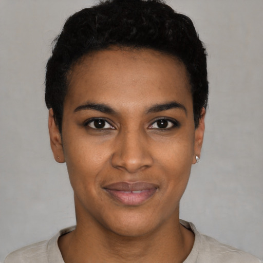 Joyful black young-adult female with short  black hair and brown eyes