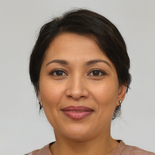 Joyful latino adult female with medium  brown hair and brown eyes