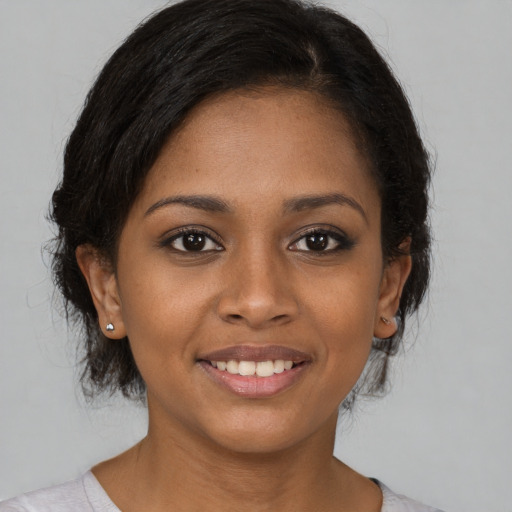 Joyful black young-adult female with medium  brown hair and brown eyes