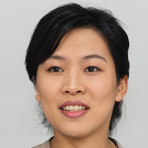 Joyful asian young-adult female with medium  black hair and brown eyes
