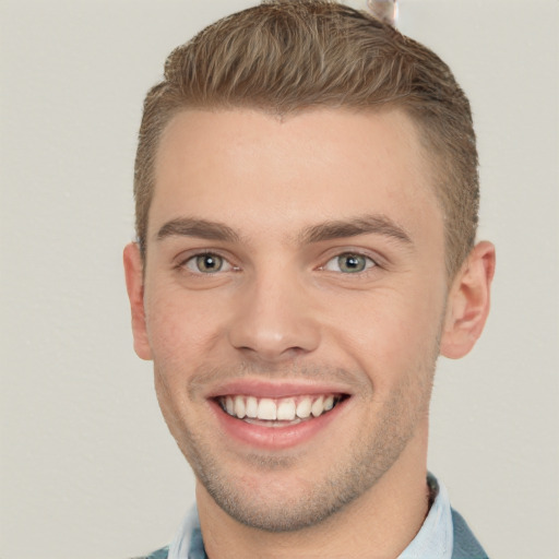 Joyful white young-adult male with short  brown hair and grey eyes