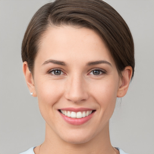 Joyful white young-adult female with short  brown hair and grey eyes