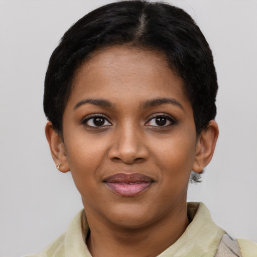 Joyful black young-adult female with short  black hair and brown eyes