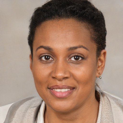 Joyful black young-adult female with short  brown hair and brown eyes