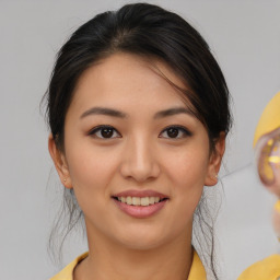 Joyful asian young-adult female with medium  brown hair and brown eyes