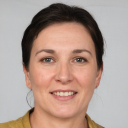 Joyful white adult female with medium  brown hair and grey eyes