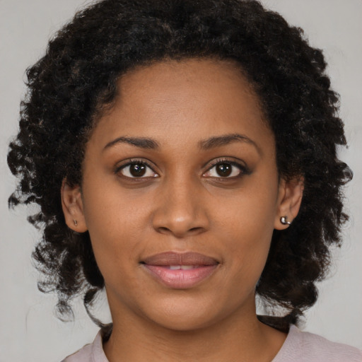 Joyful black young-adult female with medium  brown hair and brown eyes