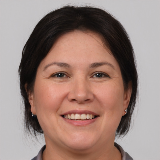 Joyful white adult female with medium  brown hair and brown eyes