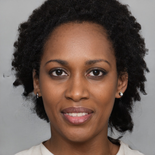 Joyful black young-adult female with medium  black hair and brown eyes