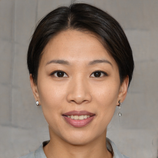 Joyful asian young-adult female with medium  brown hair and brown eyes