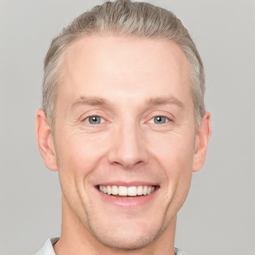 Joyful white adult male with short  brown hair and grey eyes