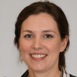 Joyful white adult female with medium  brown hair and grey eyes