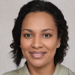 Joyful black young-adult female with long  brown hair and brown eyes