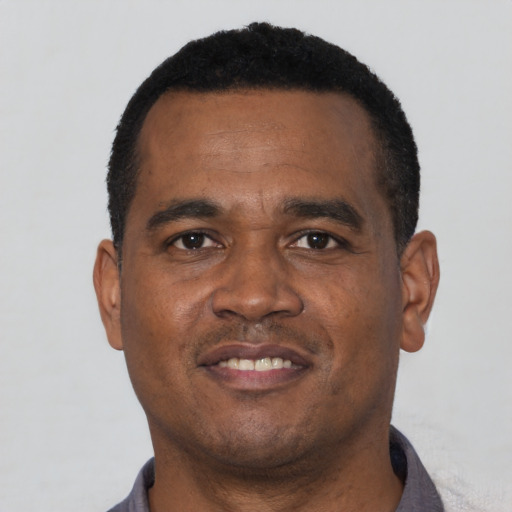 Joyful black young-adult male with short  black hair and brown eyes