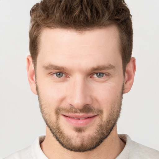 Joyful white young-adult male with short  brown hair and grey eyes