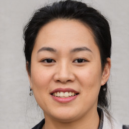 Joyful asian young-adult female with medium  brown hair and brown eyes