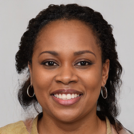 Joyful black young-adult female with medium  brown hair and brown eyes