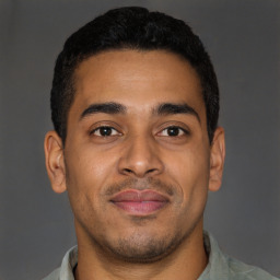 Joyful latino young-adult male with short  brown hair and brown eyes