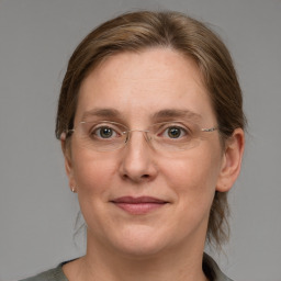 Joyful white adult female with medium  brown hair and blue eyes