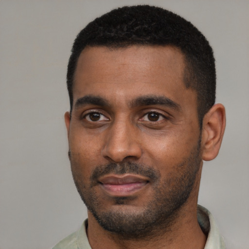 Joyful black young-adult male with short  black hair and brown eyes