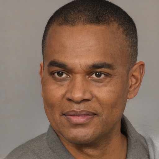 Joyful black adult male with short  brown hair and brown eyes