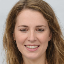 Joyful white young-adult female with long  brown hair and green eyes