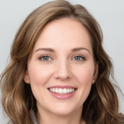 Joyful white young-adult female with long  brown hair and green eyes