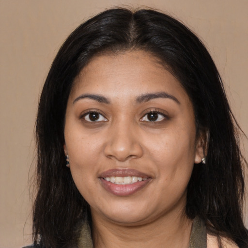 Joyful black young-adult female with long  brown hair and brown eyes