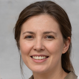 Joyful white adult female with medium  brown hair and grey eyes