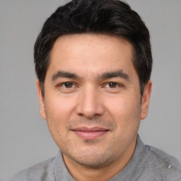 Joyful white adult male with short  black hair and brown eyes