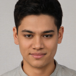 Joyful latino young-adult male with short  brown hair and brown eyes