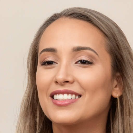 Joyful white young-adult female with long  brown hair and brown eyes