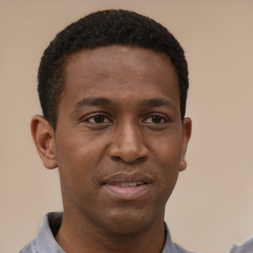 Joyful black young-adult male with short  brown hair and brown eyes