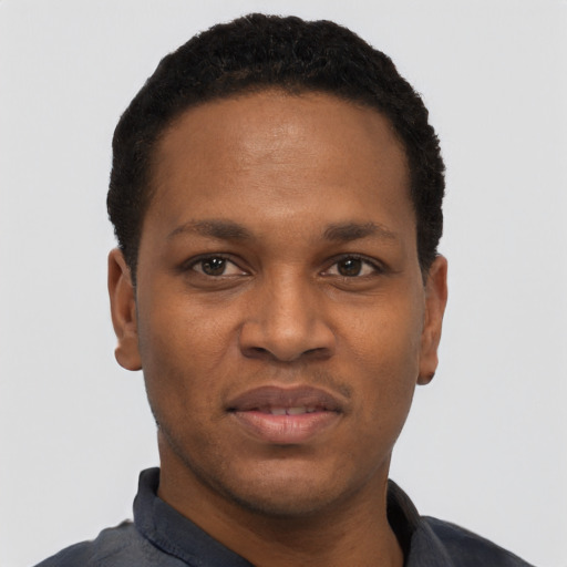 Joyful black young-adult male with short  black hair and brown eyes