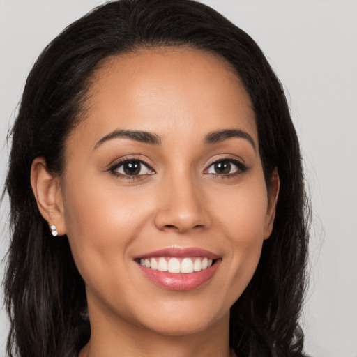 Joyful latino young-adult female with long  brown hair and brown eyes