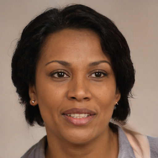 Joyful black adult female with medium  brown hair and brown eyes