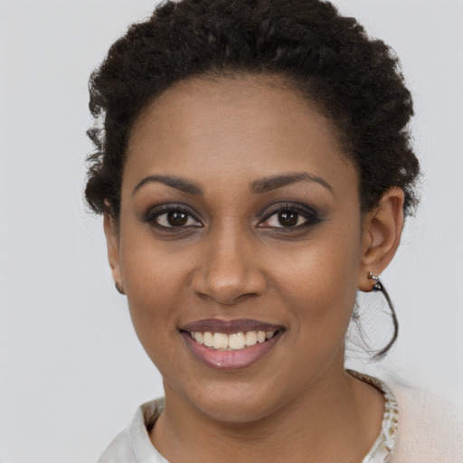 Joyful black young-adult female with short  brown hair and brown eyes