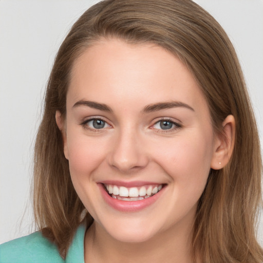 Joyful white young-adult female with long  brown hair and grey eyes