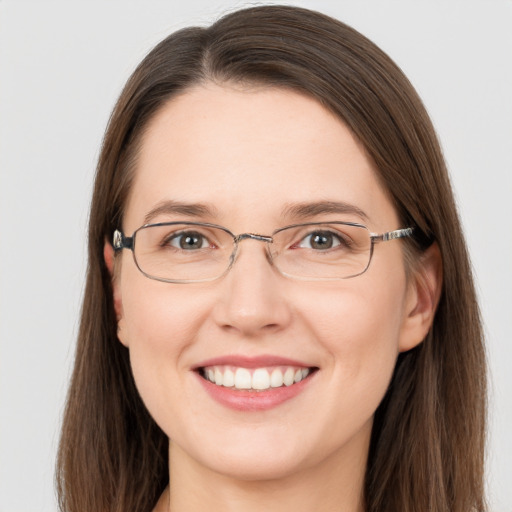 Joyful white adult female with long  brown hair and grey eyes