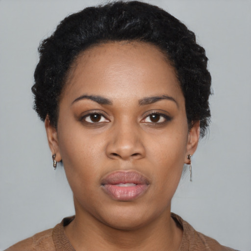 Joyful black young-adult female with short  black hair and brown eyes