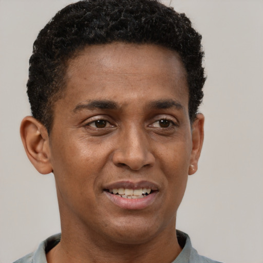 Joyful black young-adult male with short  brown hair and brown eyes