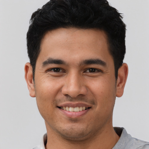 Joyful latino young-adult male with short  black hair and brown eyes