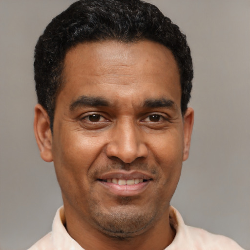 Joyful latino adult male with short  brown hair and brown eyes