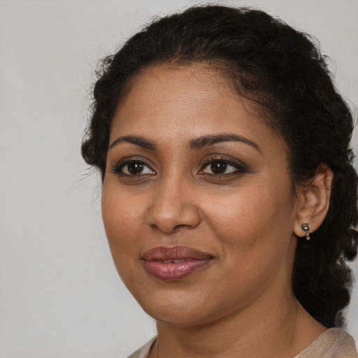 Joyful black adult female with medium  brown hair and brown eyes